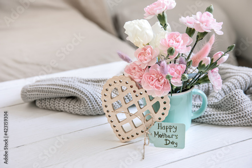 Cozy spring still life with fresh flowers and a decorative heart for Mother's Day.