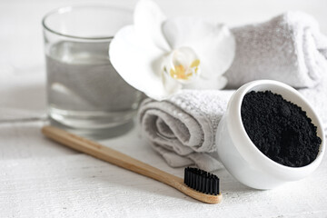 Close up of black natural teeth whitening powder and toothbrush.