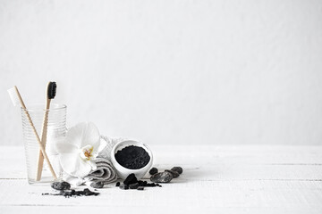 Composition with bamboo toothbrushes, teeth whitening powder and orchid flower.