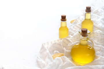 Three raw vegetable oils in a beautiful glass bottle on a white tablecloth and background, cedar, sunflower and olive.
