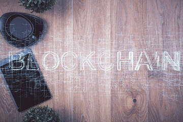 Double exposure of blockchain theme hologram over table with phone. Top view. Crypto technology...