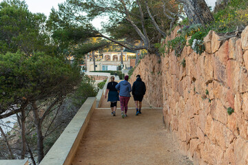 Fototapeta na wymiar Family walking along the Camino de Ronda from S'Agaró to Sa Conca