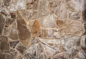 the wall is made of decorative wild stone texture of gray beige color