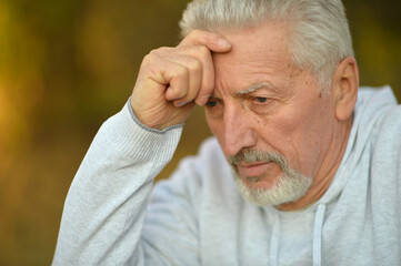 portrait of thinking senior man  in  park