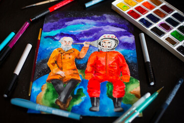 Watercolor picture of the first Russian cosmonaut Gagarin and scientist Tsiolkovsky, palette, brushes and markers