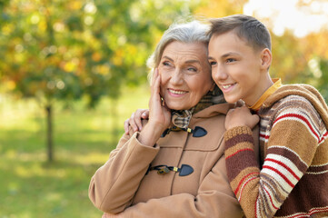 happy grandmother  and grandson posing in park