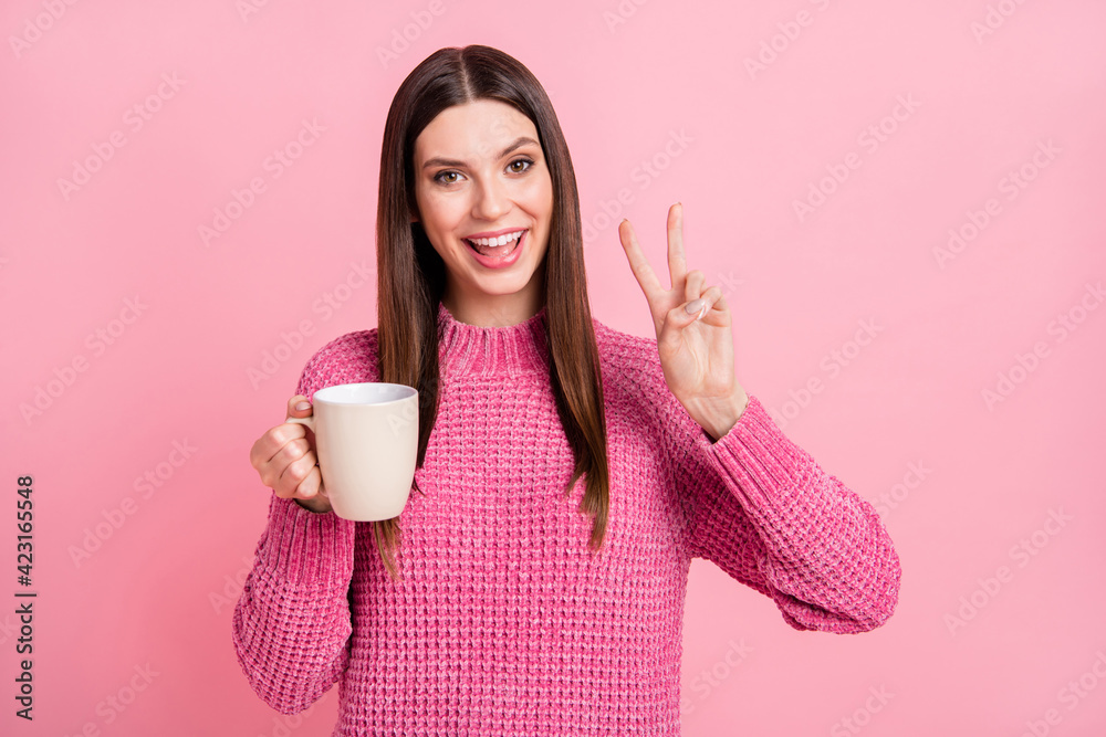 Sticker photo of excited pretty young woman dressed knitted sweater smiling drinking beverage showing v-sign