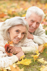 portrait of beautiful senior couple lying on grass