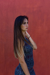 Fototapeta premium Portrait of young woman moving her long hair. She wears a short dress. It is located in Las Americas, Tenerife