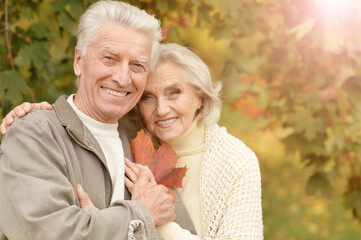 portrait of beautiful senior couple with leaves  in the park