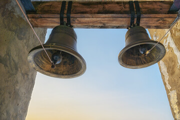Old cast iron bells on an ancient bell tower in the provincial Ural city of Cherdyn (Russia)....