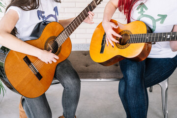 Female musician playing guitar near plant