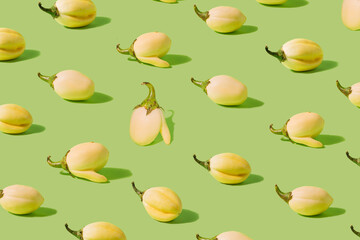 Pattern made of white eggplants on pastel green background.