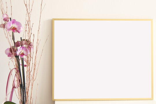 empty landscape frame for pictures, arts and photography on white table with pink orchid flower