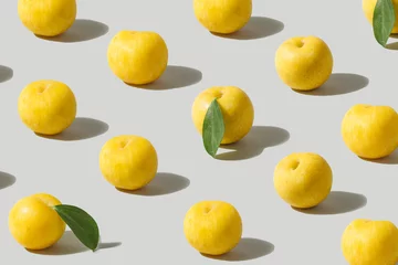 Muster aus frischen gelben Pflaumenfrüchten, die vor dem ultimativen grauen Hintergrund ausgerichtet sind. © DPA