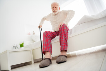 Low angle view full body photo of aged man pensioner unhappy sad unhealthy try to stand lean on stick home indoors - Powered by Adobe