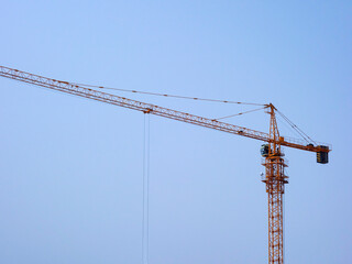 The tower crane on the construction site is busy working
