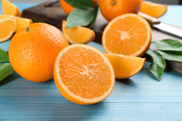 Delicious ripe oranges on light blue wooden table