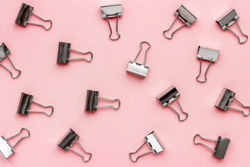 Flat lay of paper binder clips, office supplies pattern