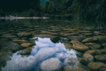 calm stream with many stones on the path