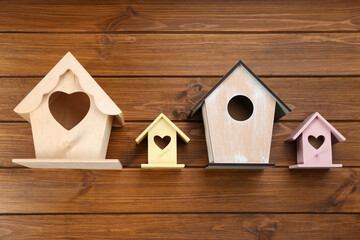 Obraz na płótnie Canvas Collection of handmade bird houses on wooden background, flat lay