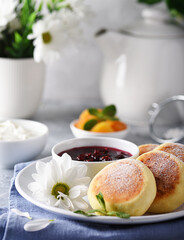 Aromatic vanilla cheesecakes with raspberry jam and sour cream for breakfast
