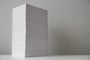 Stack of paper sheets on white table. Space for text