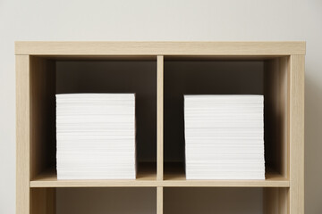 Stacks of paper sheets on shelves indoors