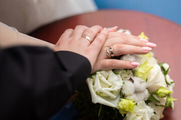 hands with wedding rings on flowers