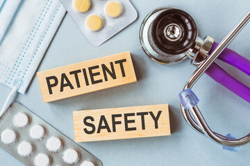 PATIENT SAFETY written on wooden cubes on medical background.