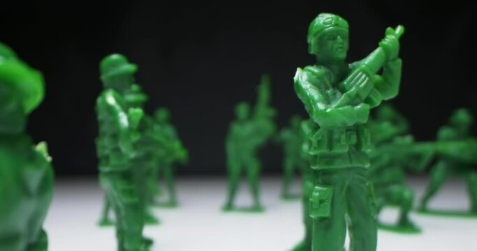 detailed extreme close-up plastic green toy soldiers arranged on black background.