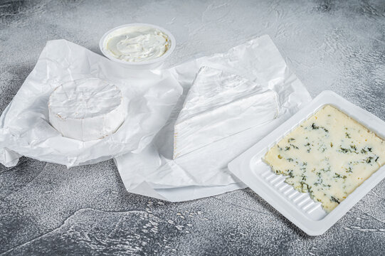 Variety Of Cheese Kinds On Kitchen Table, Brie, Camembert, Gorgonzola And Blue Creamy Cheese. White Background. Top View