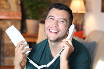 Young guy using traditional land line phone 