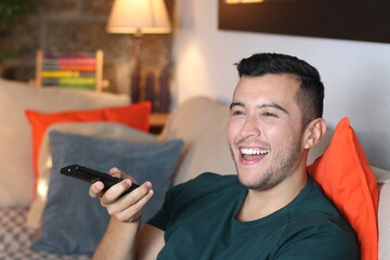 Obraz na płótnie Canvas Joyful young guy watching television