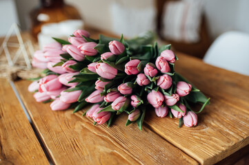 Obraz na płótnie Canvas bouquet of tulips on wood table. Border design