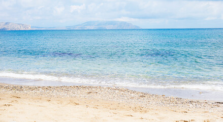 Marine background. Sky. Mountains in the distance. The sea is turquoise. Sand.