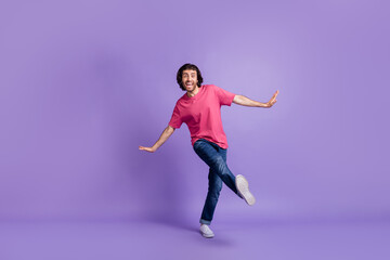 Fototapeta na wymiar Full length photo of charming cute young guy dressed pink outfit dancing walking isolated purple color background