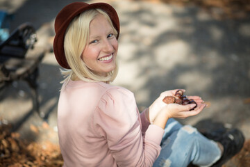 Woman in the park holding chestnuts.