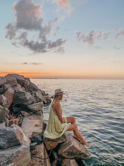 woman staring at a sunset by the lake