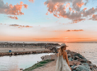 woman staring at a sunset by the lake