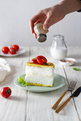 Poulard omelette with tomatoes on a plate hand sprinkles with pepper