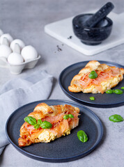 Breakfast meal croissant with salmon and scrambled eggs, basil on grey background 