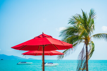 Red umbrella around sea beach ocean with coconut palm tree