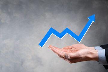 Businessman hold drawing on screen growing graph, arrow of positive growth icon.pointing at creative business chart with upward arrows.Financial, business growth concept.