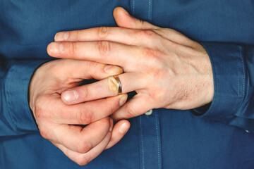 removes the wedding ring from her finger