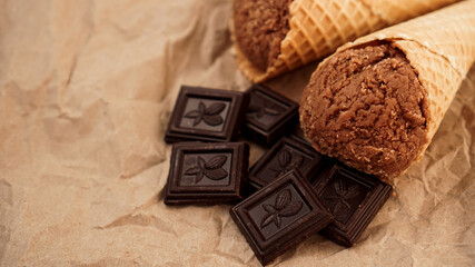 Chocolate ice cream in a waffle cone on craft paper