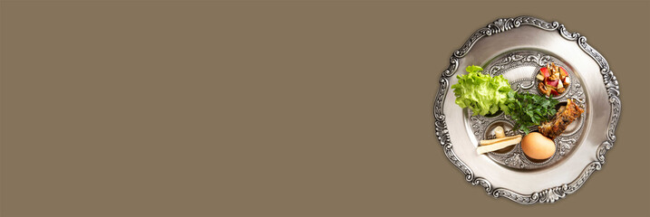 Pesach plate on a dark beige background, wide banner with a copy space. Jewish seder on occasion of...