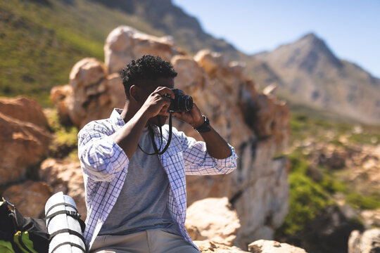 Portrait of fit african american man taking pictures outdoors in countryside to camera