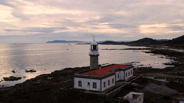 Faro abandonado en la costa en el atardecer con dron