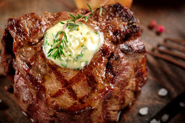 Premium grilled beef tenderloin steak with butter and thyme served on a wooden board. Roast meat...